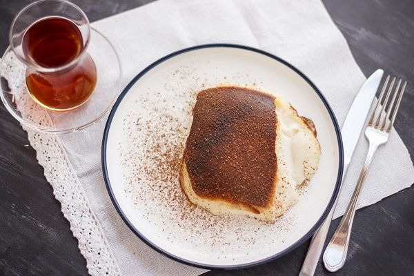 Postre turco tradicional kazandibi con canela molida y té turco