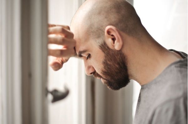 Hombre con alopecia sufriendo consecuencias psicológicas