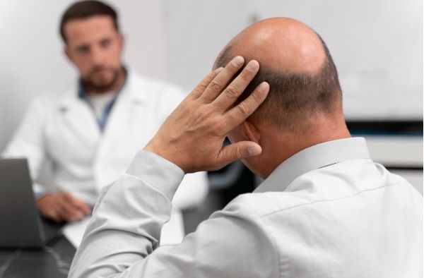 Hombre con alopecia ante el cirujano para realizarse un tratamiento capilar
