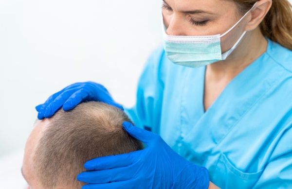 Cirujana revisando el cabello de un paciente en Turquía