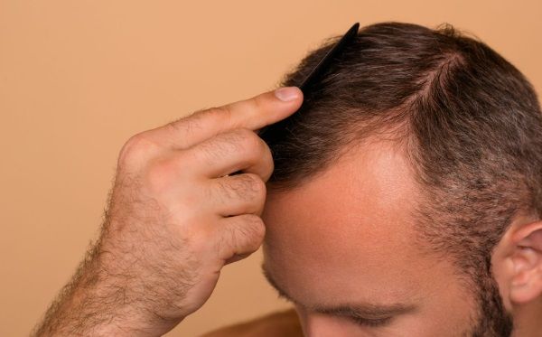Hombre de perfil peinándose con un peine