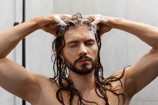 Hombre exfoliándose el pelo con un masaje