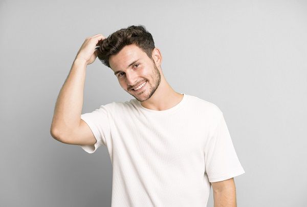 Hombre feliz tras someterse a un trasplante capilar y ver sus beneficios