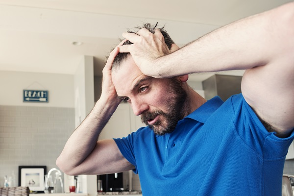 Hombre con estrés cogiéndose el pelo que sufre efluvio telógeno